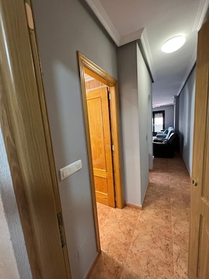 Enter a serene hallway with a door leading to a room featuring a tiled floor.