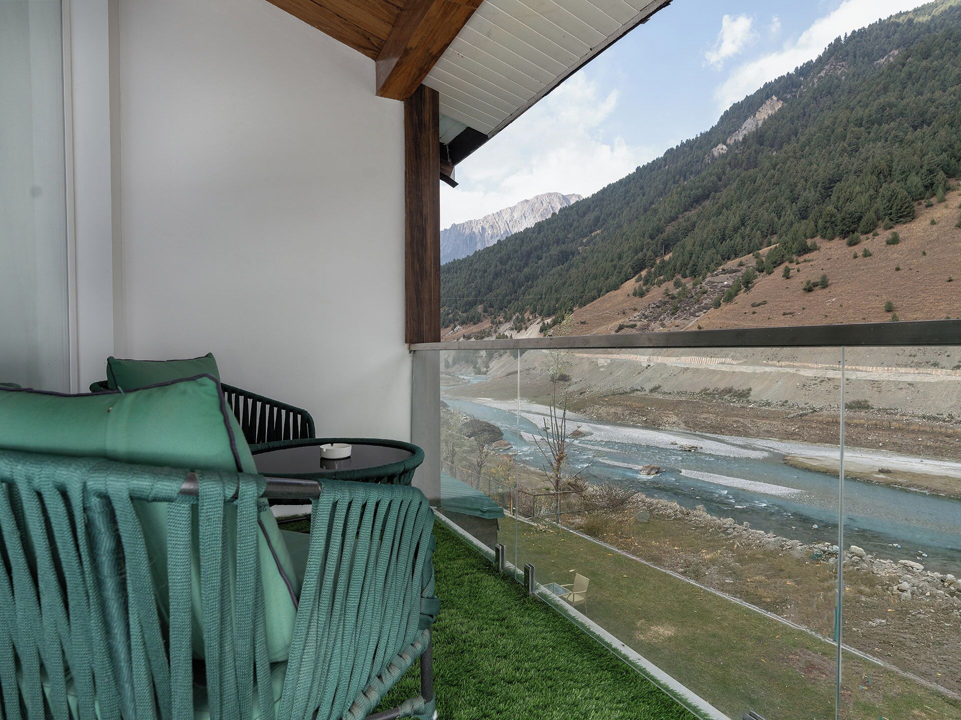 A balcony with a view of a river and mountains.