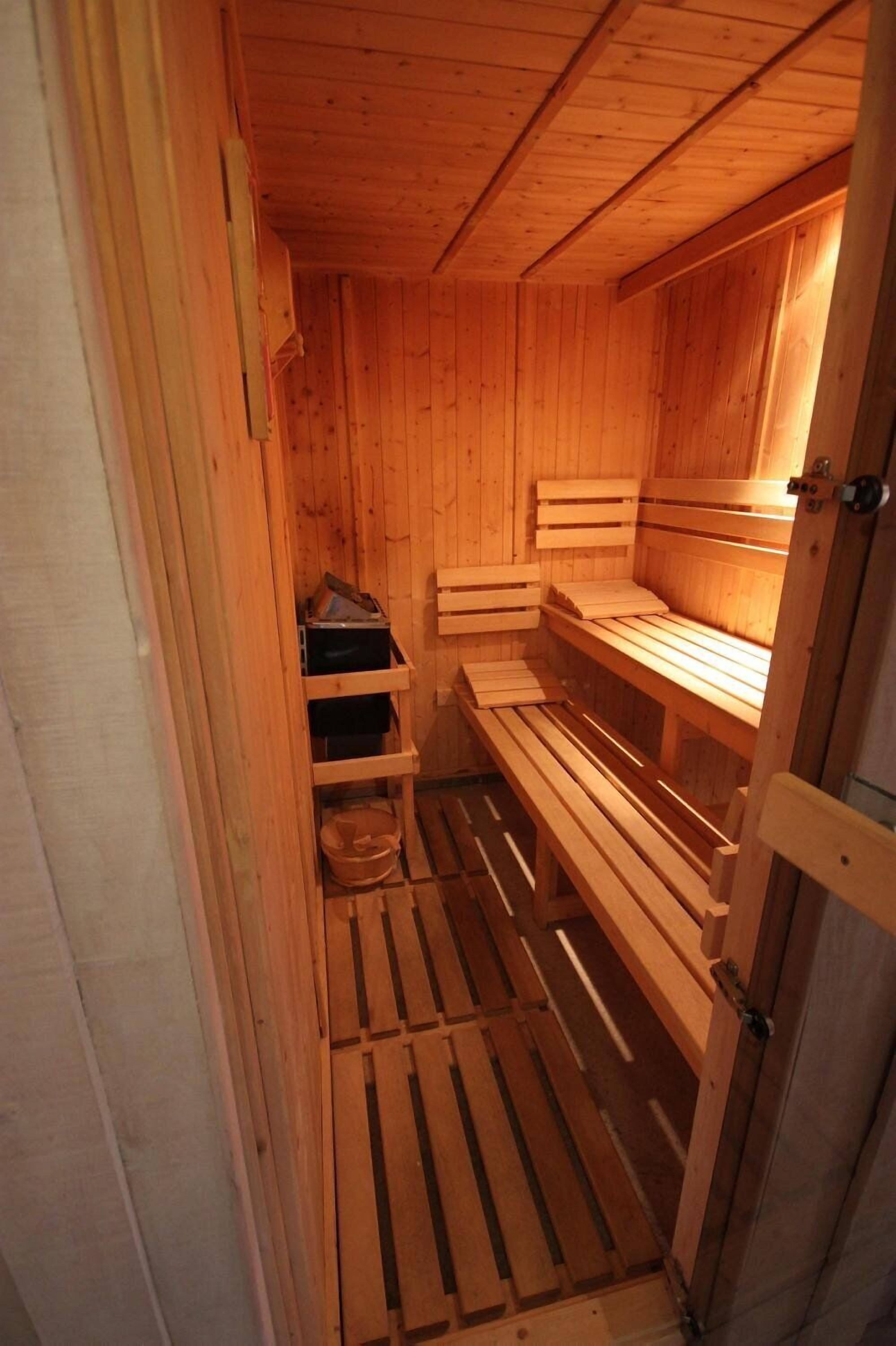 A wooden sauna with benches and shelves.