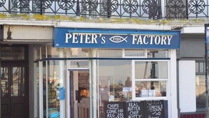 A storefront with a sign reading "PETER'S FISH FACTORY" and a chalkboard menu listing items like chips, real butter chip butty, and haddock with chips. - Magdala Cottage -Village Location- Dog Friendly (Broadstairs)
