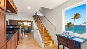 A modern kitchen with a wooden staircase leading to a balcony with a view of the ocean. - MA 1-310 AC, Fantastic Views, 2 b Loft, 2 1/2 Bath (Koloa)