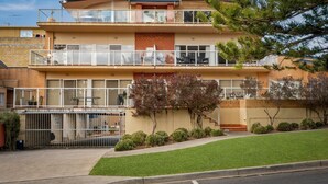 Ein zweistöckiges Wohnhaus mit Balkon, Garage und gepflegtem Rasen.
