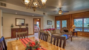 A dining area with a wooden table, chairs, a chandelier, and a ceiling fan. - Cozy Golf course condo with A/C (pagosa springs)