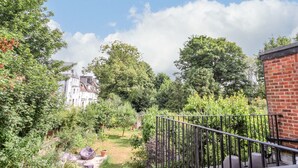 A garden with a pathway, a brick wall, and a metal railing. - Magpies (St Leonards-On-Sea)