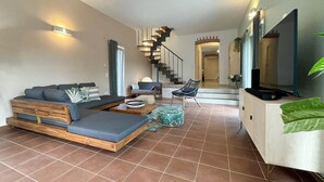 Un salon moderne avec un canapé, une table basse et un meuble pour la télévision.