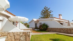 A white villa with a stone facade, a tiled roof, and a well-maintained lawn. - Vista Verde Adult Only (San Bartolomé de Tirajana)