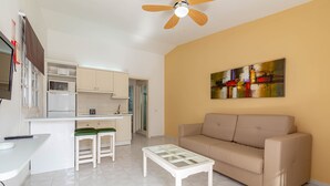 A compact living space with a kitchenette, a sofa, a coffee table, and a ceiling fan. - Vista Verde Adult Only (San Bartolomé de Tirajana)