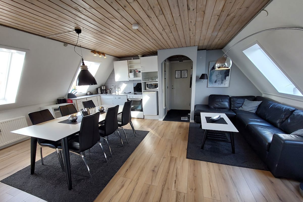A modern apartment with a dining area, kitchen, and living room.