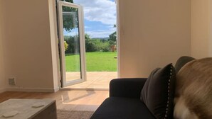 Quarto com porta de vidro deslizante que dá para um jardim.