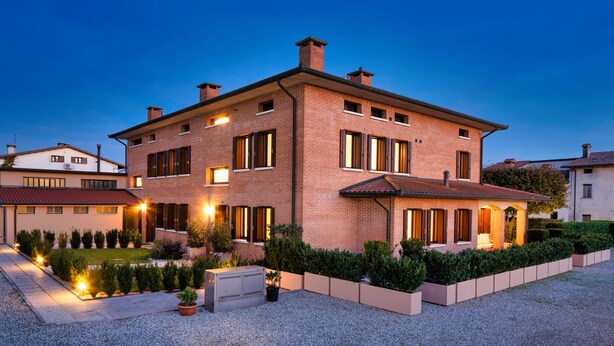 A two-story house with a brick exterior, multiple windows, and a well-maintained garden.