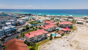 A coastal resort with multiple buildings, a swimming pool, and a beach.