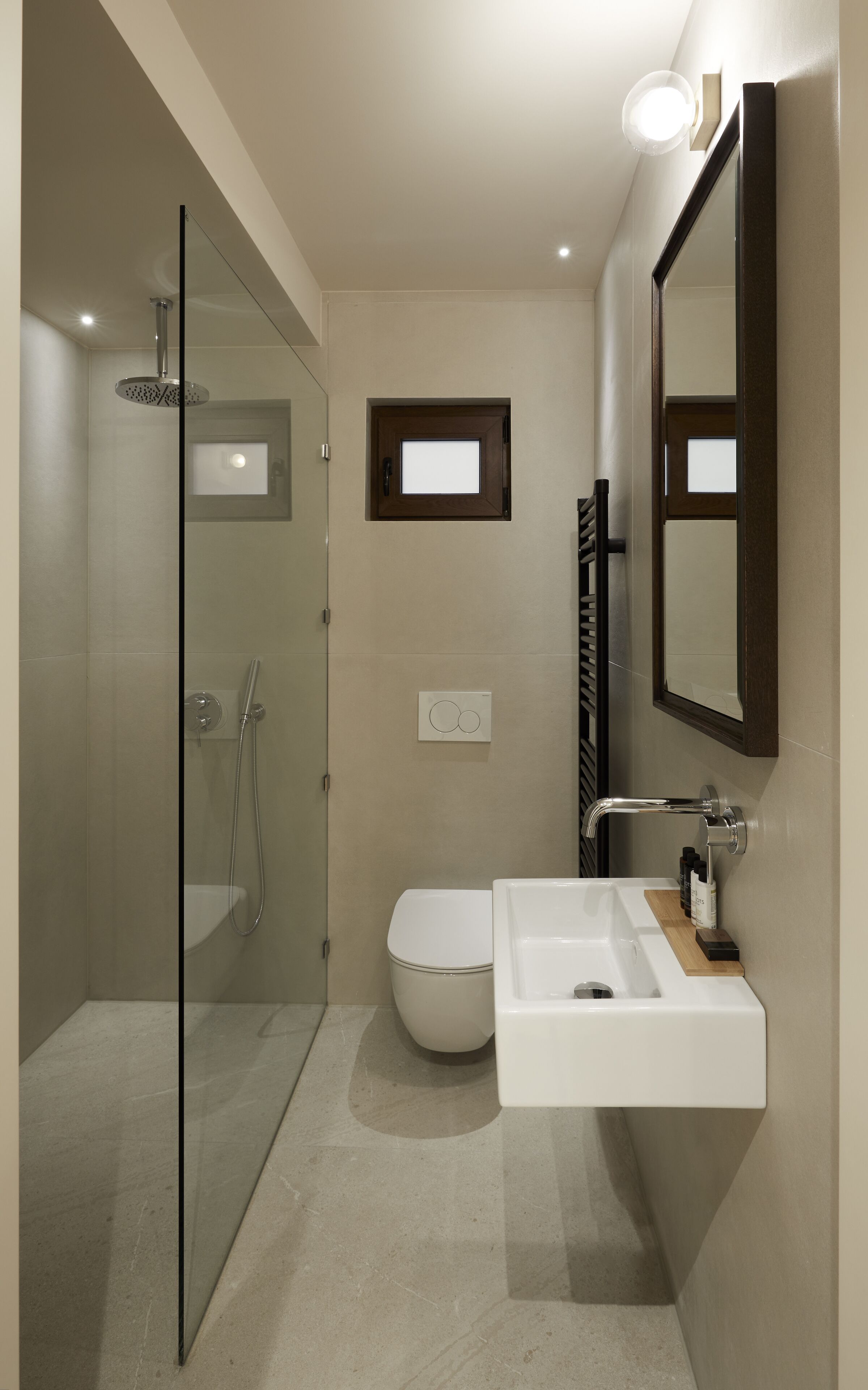 A modern bathroom with a glass shower enclosure, a toilet, and a sink with a mirror.