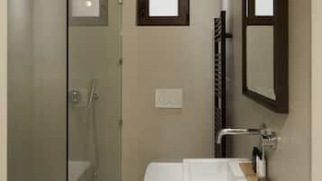 Un baño moderno con cabina de ducha de vidrio, inodoro y lavabo con espejo.