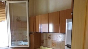 Eine Küche mit Holzausstattung, einer Arbeitsplatte und einem Kühlschrank.