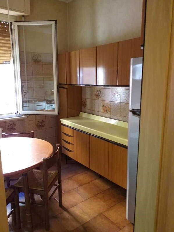 Eine Küche mit Holzausstattung, einer Arbeitsplatte und einem Kühlschrank.