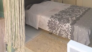 Un dormitorio con cama, dosel blanco, colcha estampada y una puerta con un reloj.