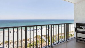 A balcony with a view of a beach and ocean.