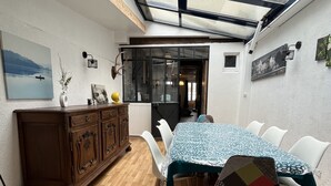 A dining area with a table set for four, a wooden cabinet, and a skylight above.