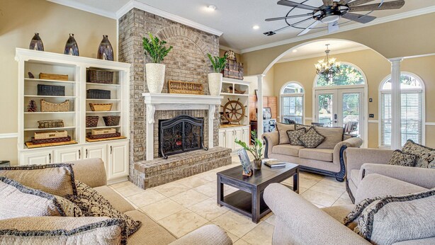 A living room with a fireplace, a ceiling fan, and a sofa. - Georgia's Nature Retreat on Old Mill Pond (Statesboro)