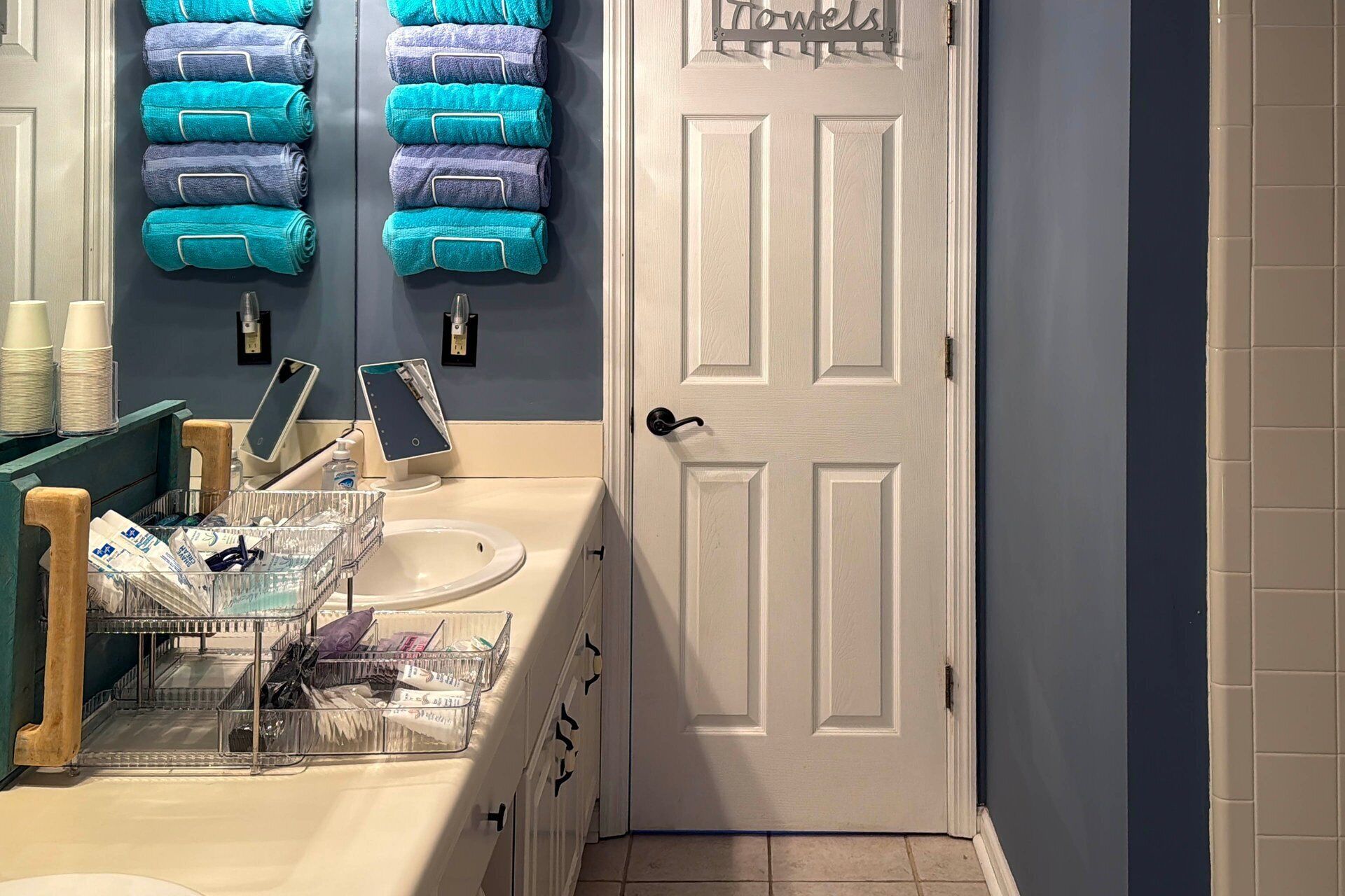 A bathroom with a sink, mirror, and towel rack.