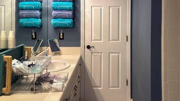 A bathroom with a sink, mirror, and towel rack.