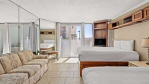 A hotel room with two beds, a sofa, a TV, and a balcony with a view. - Top Of The Gulf 111 - Ground Level Studio (Panama City Beach)