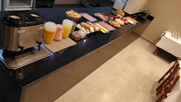 A breakfast buffet with various food items and a coffee machine.