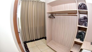 A modern room with a wooden wardrobe, a hanging rack, and a tiled floor.