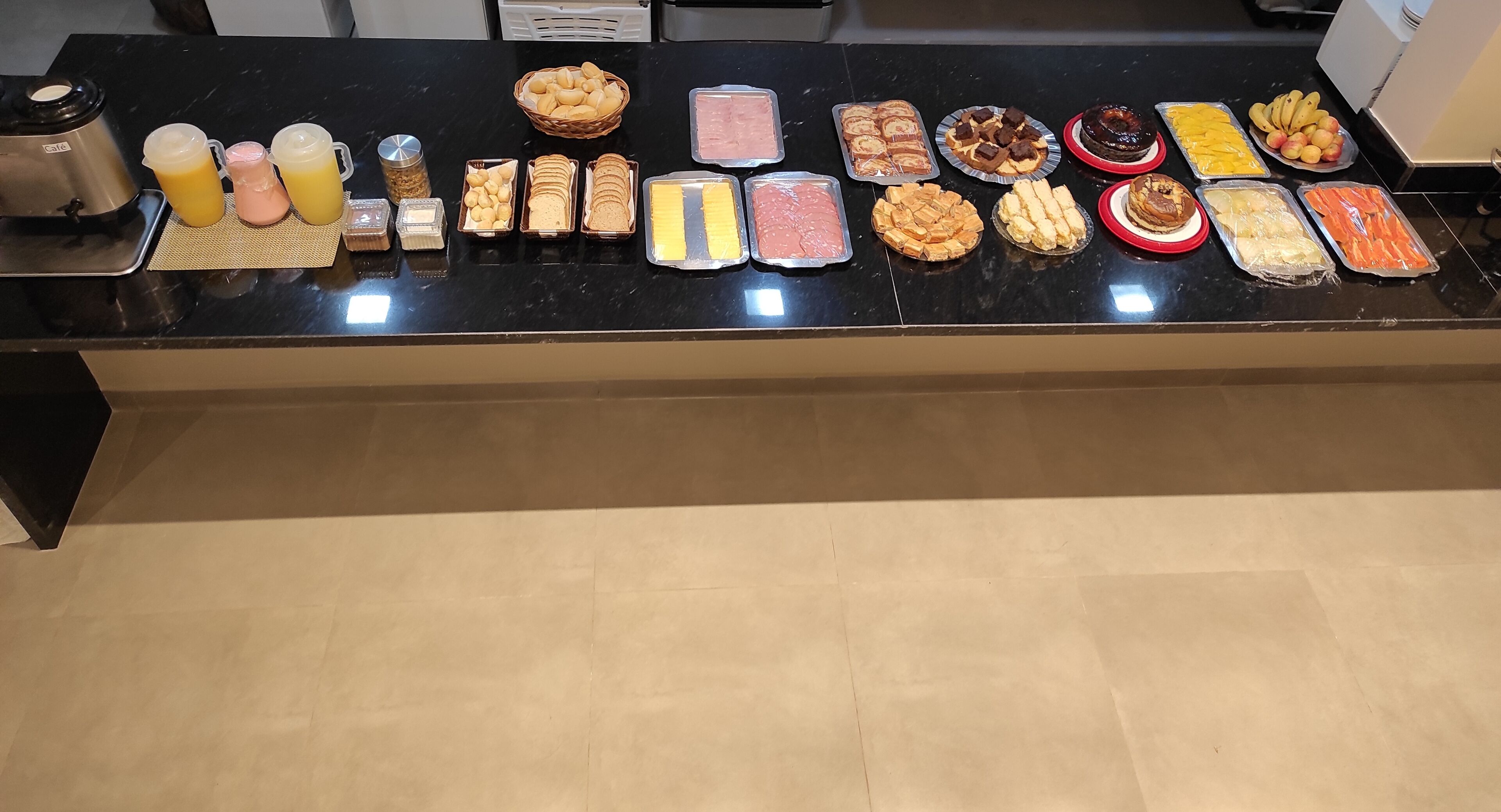 A buffet table with various food items and a coffee maker.