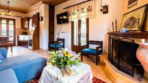 Una sala de estar acogedora con chimenea, televisión y comedor con armarios de madera.