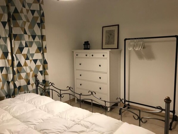 A bedroom with a bed, a dresser, a framed picture on the wall, and a whiteboard. - In the Cévennes (Générargues)