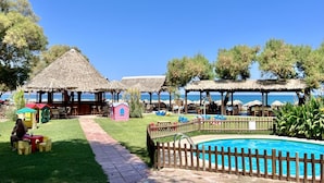 A resort with thatched-roof structures, a swimming pool, and a clear view of the sea. - Villa Artemis in Vrises (Apokoronas)