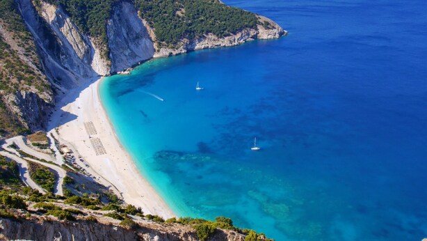 A coastal landscape with a clear blue sea, a sandy beach, and a rocky cliff. - Villa Nireaus in Sami (Kefalonia)