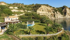 Ein Küstenanwesen mit Swimmingpool, Gazebo und Meerblick.