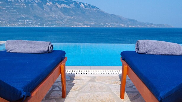 Two sun loungers with towels, a pool, and a mountainous backdrop. - Villa Odysseus in Spartia (Kefalonia)