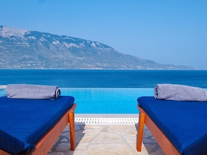 Two sun loungers with towels, a pool, and a mountainous backdrop. - Villa Odysseus in Spartia (Kefalonia)
