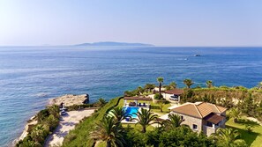 A coastal property with a swimming pool, a stone house, and a view of the sea. - Villa Odysseus in Spartia (Kefalonia)