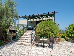 Relax on the patio surrounded by lush greenery and enjoy the sea view.