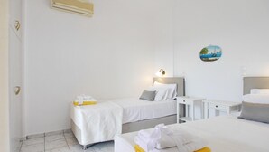 A hotel room with two beds, a desk, and a bathroom. - Villa Emiliata in Spartia (Kefalonia)