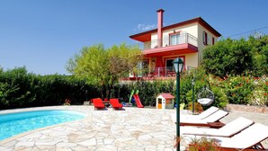 A two-story house with a swimming pool, stone patio, and red and white exterior. - Villa Emiliata in Spartia (Kefalonia)