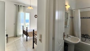 A bathroom with a sink, mirror, and shower. - Villa Kephalos in Spartia (Kefalonia)