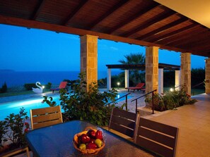 An outdoor patio with a pool, stone pillars, and a swan sculpture. - Villa Dionysos in Spartia (Kefalonia)