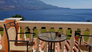 A balcony with a table and chairs overlooking a body of water and mountains. - Villa Dionysos in Spartia (Kefalonia)