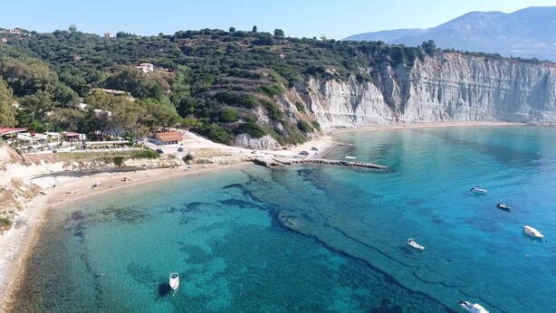 A coastal area with clear turquoise waters, a sandy beach, and a rocky cliff. - Villa Hephaestus in Spartia (Kefalonia)
