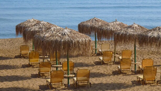 A beach with rows of sun loungers and thatched umbrellas. - Rouladina Apt 4 in Stalos (Chania)