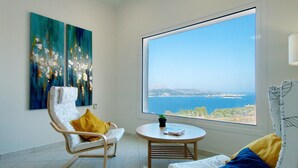 A room with two chairs, a small table, and a large window offering a view of the sea. - Villa Nikos in Megala Chorafia (Chania)