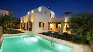 A modern two-story house with a swimming pool, outdoor seating, and a well-lit patio area. - Villa Argiro in Plaka (Apokoronas)
