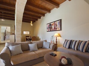 Cozy living space with a high ceiling, sofa, and dining area.