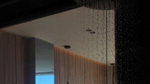 A modern hotel room with a large bed, a view of the sea, and a glass partition. - Esbjerg Hotel (Vlorë)