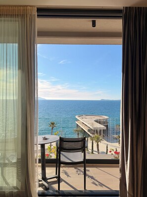 Ein Balkon mit Meerblick, einem Stuhl und einem Tisch.